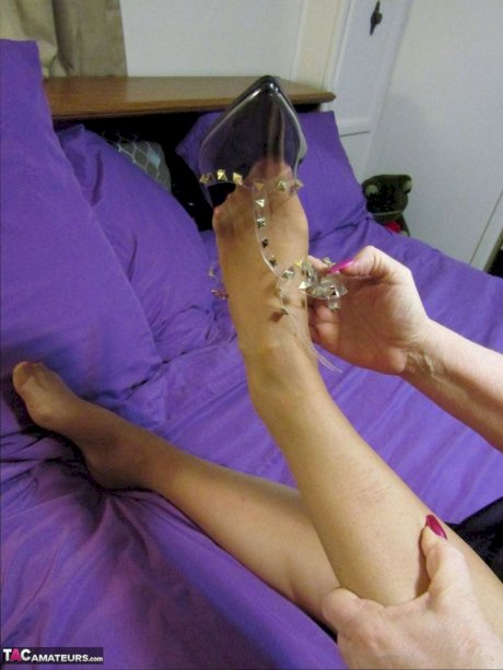 Old woman Bunny Gram shows her hose covered pussy on a bed in pointy shoes