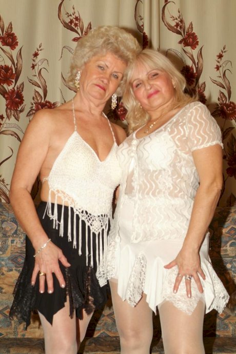 Blonde grandmothers engage in lesbian foreplay on a chesterfield