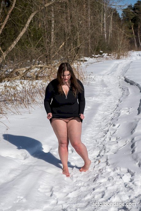 Brunette BBW rids ball gag and ropes while posing nude and barefoot in snow