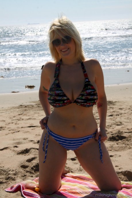 Chubby blonde sunbather Siri flaunts her big tits in a bikini on the beach