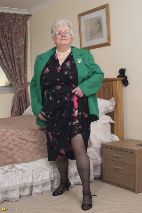 Older granny is still horny and plays with her fatty pussy on the bed