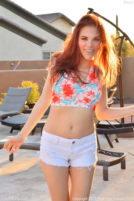 Beautiful redhead Devyn toys her pussy indoors and on a patio as well
