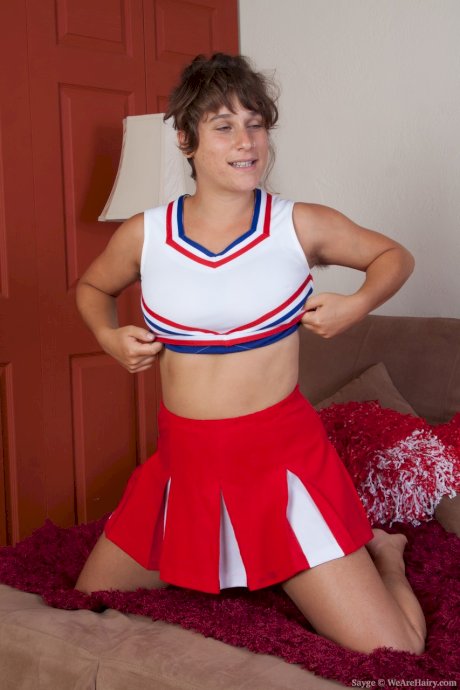 Nasty cheerleader Sayge poses in the bedroom and shows her muff