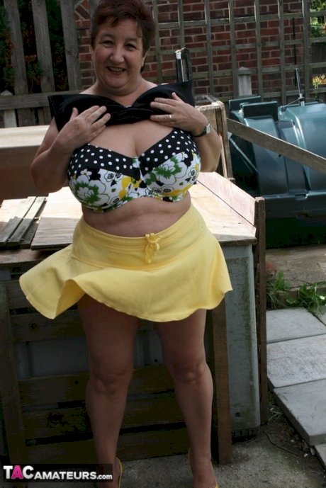 Fat older woman Kinky Carol flashes her bra and upskirt underwear on a patio