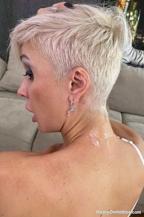 Inked platinum blonde Tanya Virago holds a cock after showing her pierced cunt