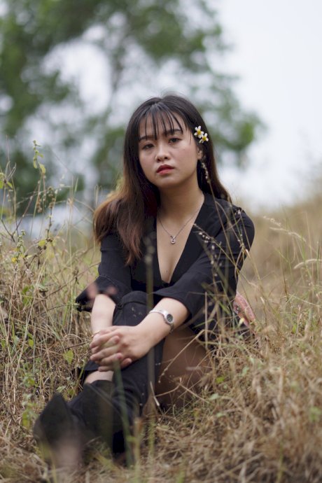 Gorgeous Asian babe posing in her black dress and boots in nature