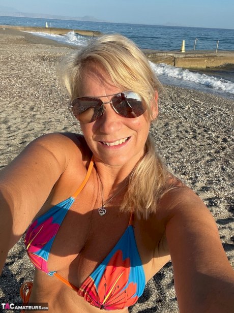 Middle-aged blonde Sweet Susi releases her natural tits and twat from a bikini