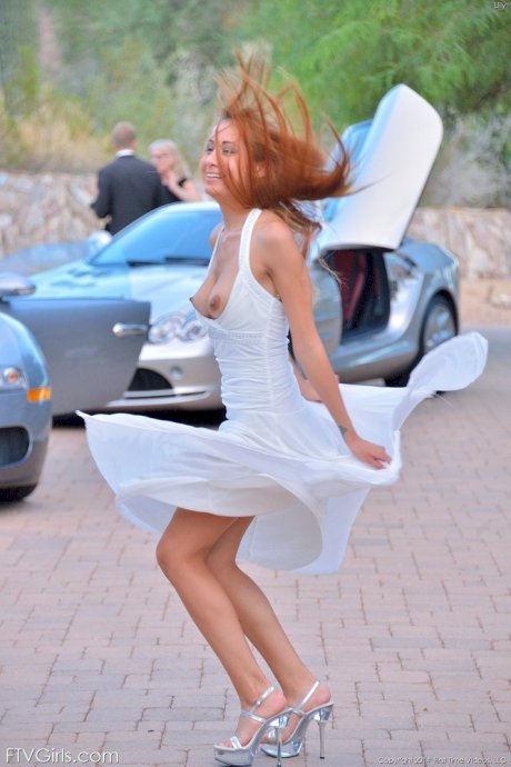 Sexy redhead with big hard nipples flashes naked upskirt in the driveway