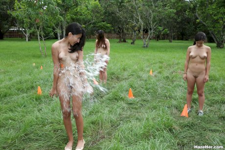 Pretty naked lesbians are standing naked and showing their bodies outdoor