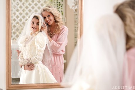 Carolina Sweets is affixed with a garter before a lesbian wedding to Julia Ann
