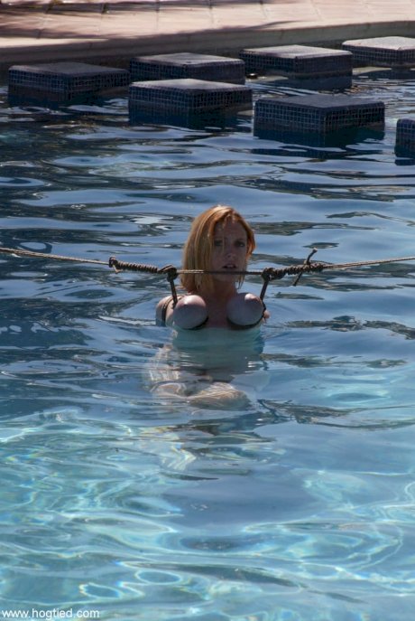 Thick redhead is hogtied in a swimming pool before being freed - Photo 6