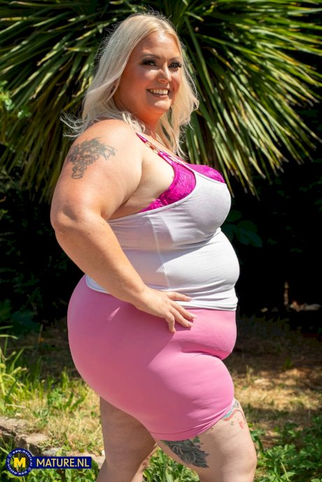 Middle-aged blonde woman displays her massive ass after washing her car - Photo 1