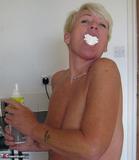 Older woman with short blonde hair Shazzy B covers her tits & twat in cream
