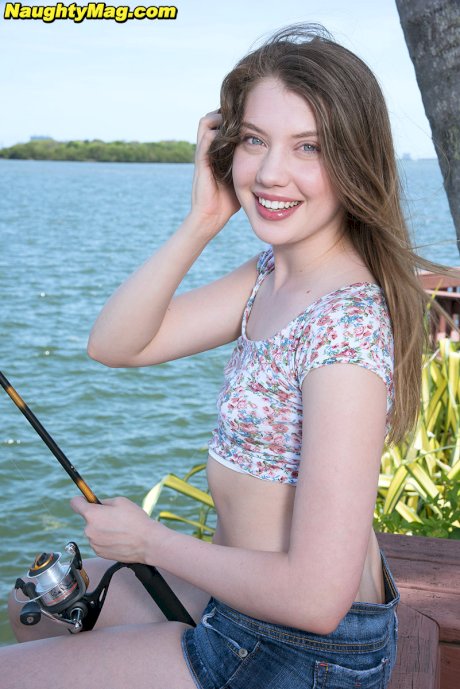 Sweet teen Elena Koshka uncovers her tiny breasts while fishing from shore
