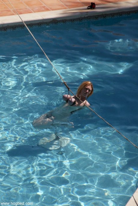 Thick redhead is hogtied in a swimming pool before being freed - Photo 8