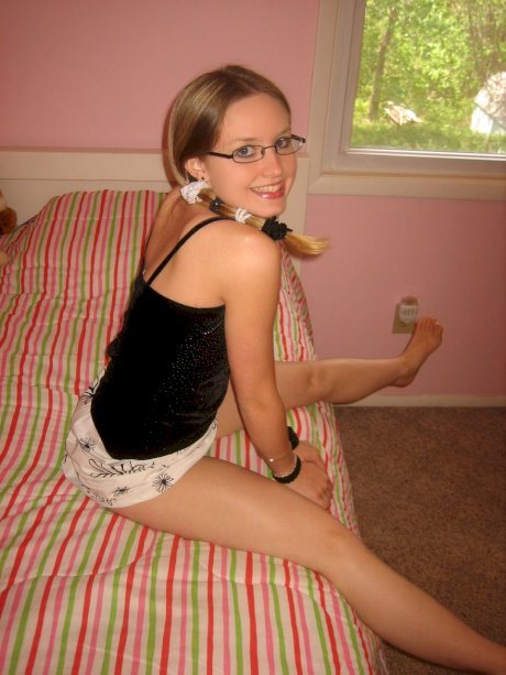 Geeky teen Kitty strips, shows her round booty and toys her pink twat