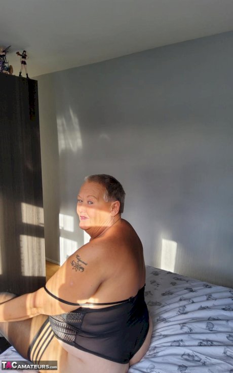 Overweight granny Valgasmic Exposed uncovers her boobs on her bed in stockings
