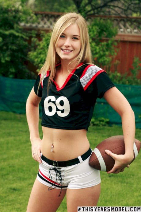 Beautiful blonde Jewel doffs sportswear to pose nude while holding a football