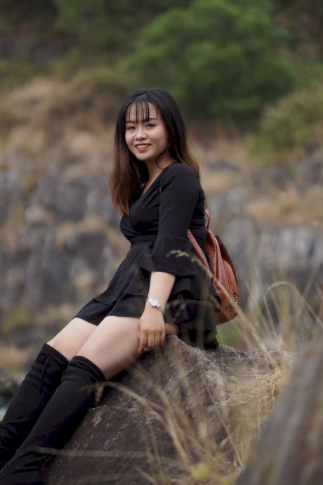 Gorgeous Asian babe posing in her black dress and boots in nature