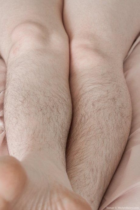 Nasty brunette Tamar showing her hairy legs and cunt in solo in the bedroom - Photo 3