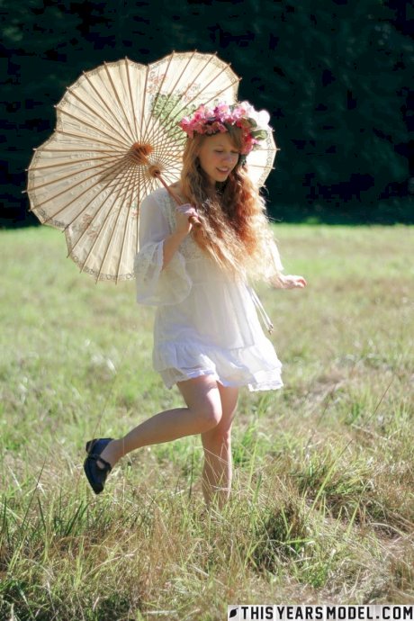 Charming redheaded teen Dolly Little holds a parasol while getting naked - Photo 2