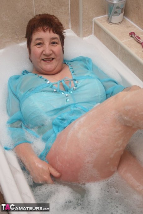 Redhead nan Kinky Carol parks her fat figure in a tub while fully clothed