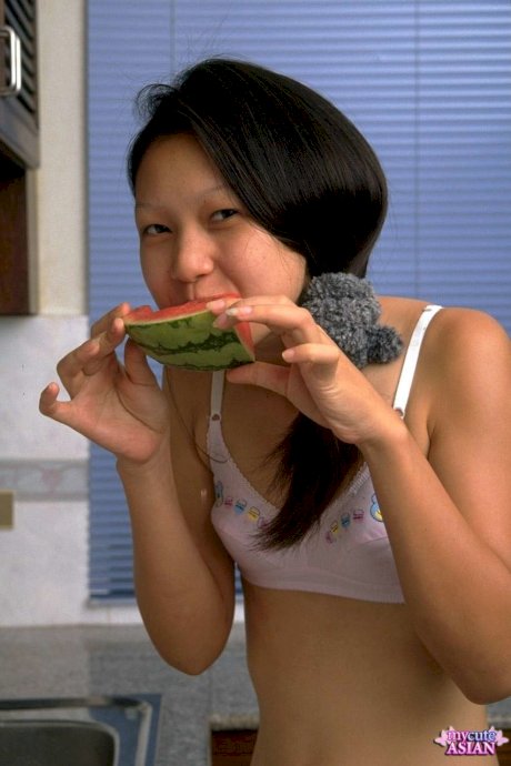 Charming Asian teen removes lace underwear while eating a watermelon