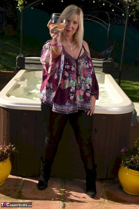 Fat older blonde Melody peels off black leggings afore an outdoor hot tub