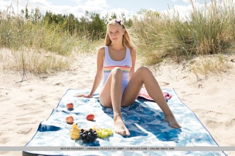 Young blonde Beti reveals her tan lined body on a beach blanket