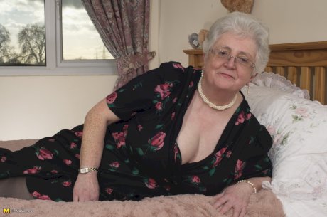 Older granny is still horny and plays with her fatty pussy on the bed