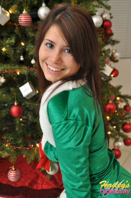 Amateur Xmas elf Hailey lifts her tight skirt to show her sexy ass by the tree