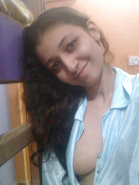 Indian solo girl holds her face firm while letting nipples free of lingerie