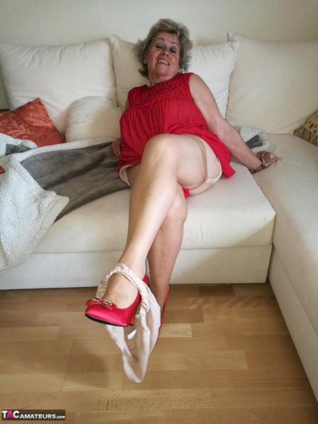 Horny oma Caro hikes up long red dress to spread her hairy vagina