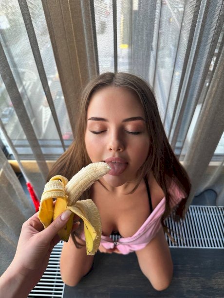 Saucy OnlyFans teen Vi Angel poses in her pink lingerie while eating a banana
