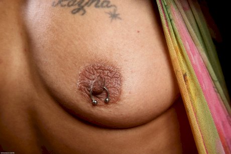 Short haired black woman with pierced nipples tries her hand at nude modeling