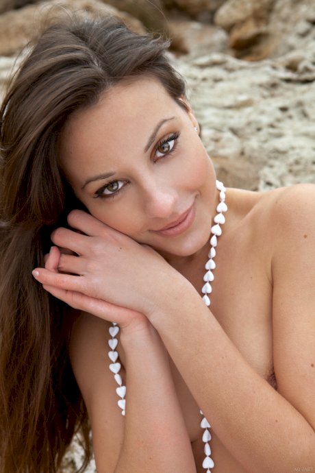 Brunette beauty Lorena B poses naked and plays with sand on the beach