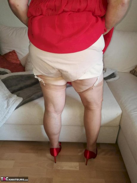 Horny oma Caro hikes up long red dress to spread her hairy vagina