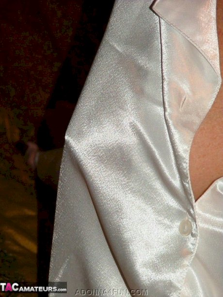 Blonde nan Adonna toys her pierced pussy on a bed in a robe and stockings