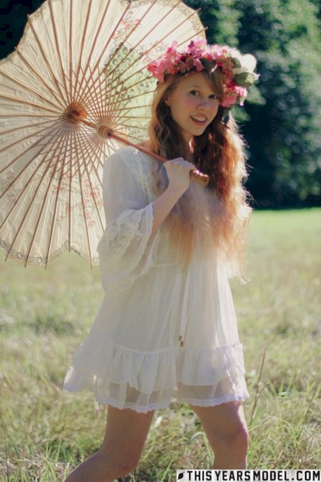 Charming redheaded teen Dolly Little holds a parasol while getting naked - Photo 3