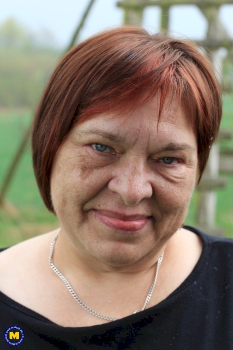 Redhead granny Sheila reveals her swollen vagina on an outdoor ladder