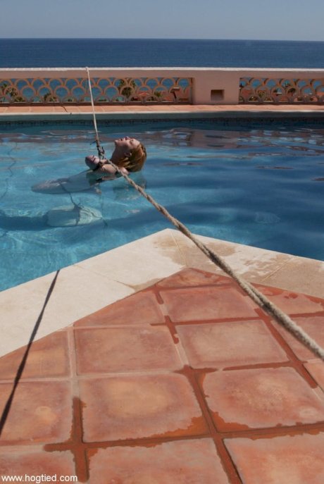 Thick redhead is hogtied in a swimming pool before being freed - Photo 5