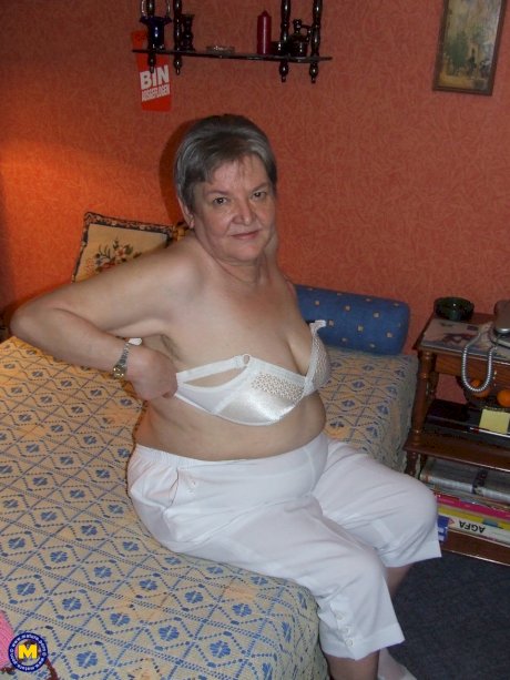 Fat granny Uschi doffs her clothes, poses naked and masturbates on a bed