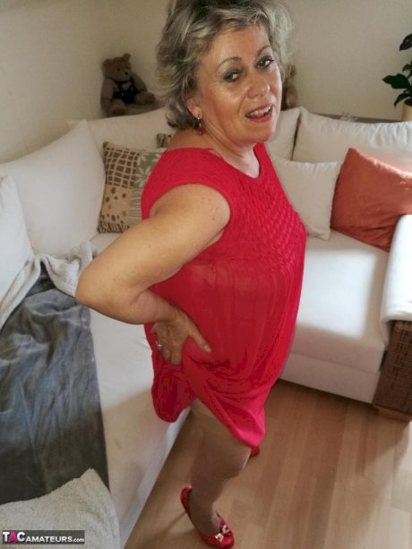 Horny oma Caro hikes up long red dress to spread her hairy vagina