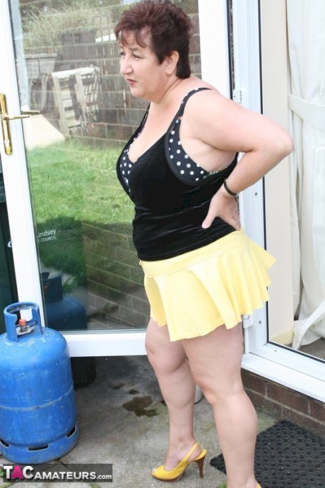 Fat older woman Kinky Carol flashes her bra and upskirt underwear on a patio
