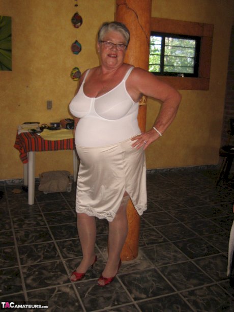Fat granny Girdle Goddess holds her saggy tits in her hands by a pillar