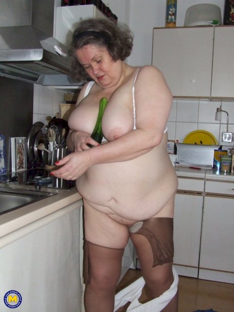 Fat mature housewife Birgid masturbates with a cucumber in the kitchen