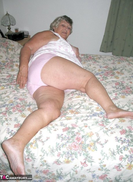 Old woman Grandma Libby grabs her fat roll after getting naked on a bed