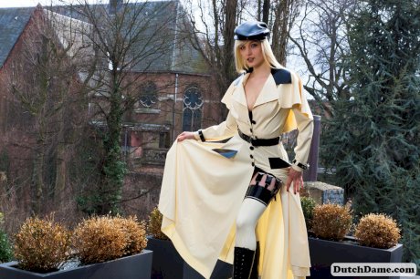 Hot blonde flashes latex garters while modeling outdoors in rubber attire