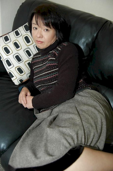 Mature Asian woman Tomoe Nakamachi undresses to reveal tiny tits porn pics