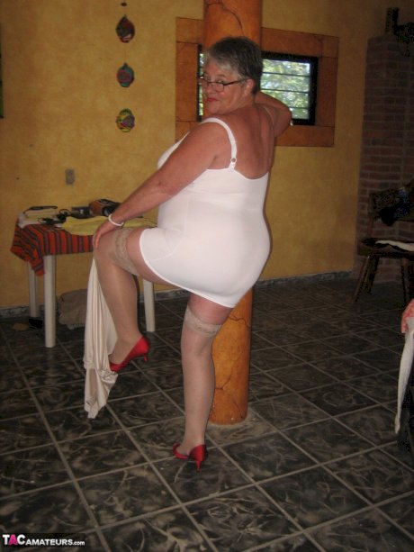Fat granny Girdle Goddess holds her saggy tits in her hands by a pillar